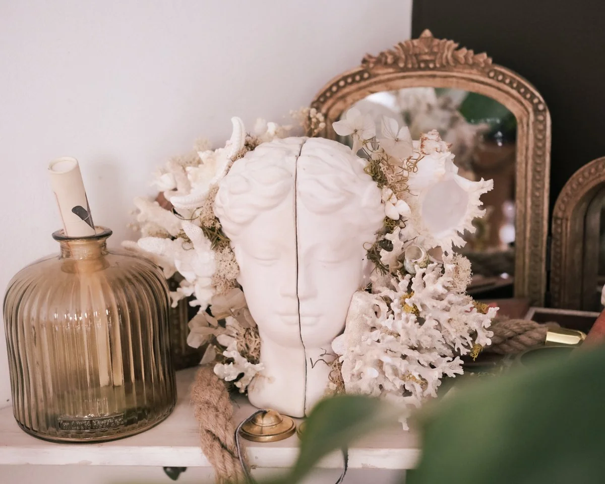 A carved coral sculpture and a white statue head on a vanity