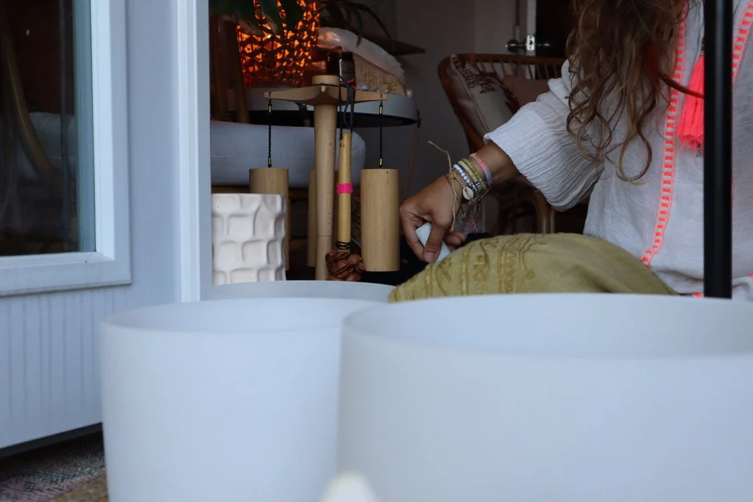 A woman playing crystal singing bowls during a guided Intraspective meditation during a Group Therapy session.